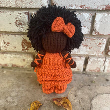 Load image into Gallery viewer, Loom Knit Black Doll Project Pattern Copyright Loomahat Doll made with 24 peg round loom and orange Red Heart yarn.
